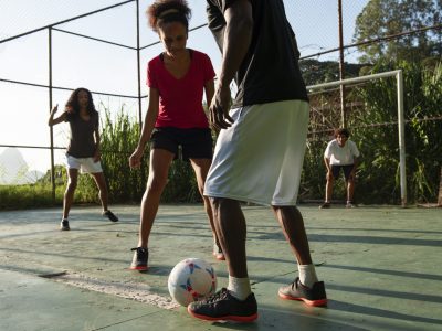 vista-lateral-amigos-jogando-futebol